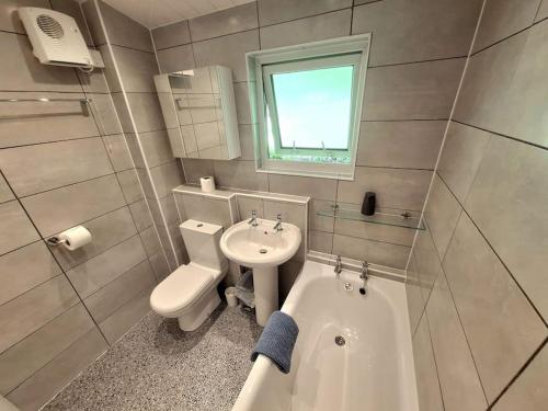 a bathroom with a sink and a toilet and a tub at Kiberick Cottage at Crackington Haven, near Bude and Boscastle, Cornwall in Bude