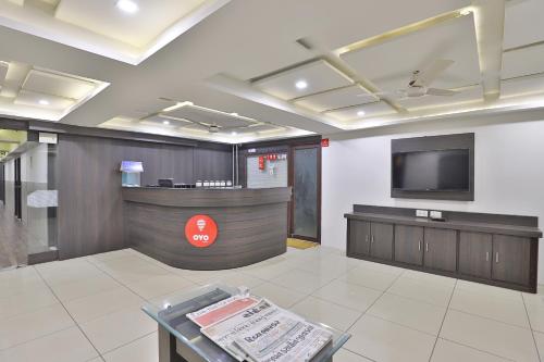 a lobby with a waiting area with a tv at Hotel Nova Cross Road in Rajkot