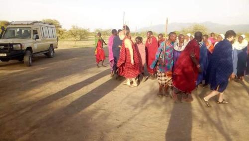 a group of people standing on the side of a road at SURUNGAI EMANYATA Maasai Boma in Arusha