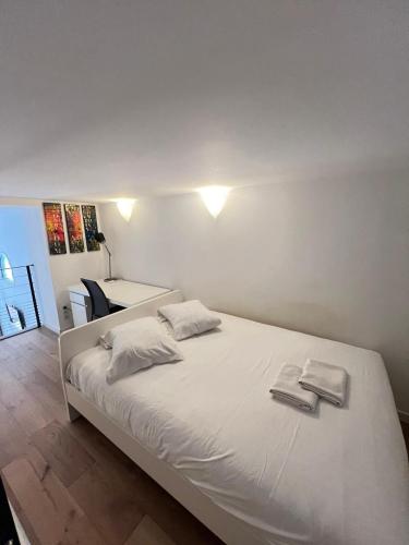une chambre avec un lit blanc avec deux serviettes dessus dans l'établissement Magnifique Duplex Type Loft, à Nice
