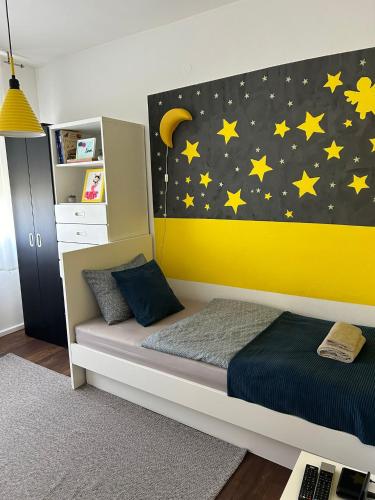 a bedroom with a bed with a moon and stars on the wall at Apartman Gaby in Virovitica