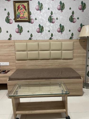 a bench with a glass table in front of a wall at Hotel Seth Murlidhar Seva Sadan-Near Prem Mandir in Vrindāvan