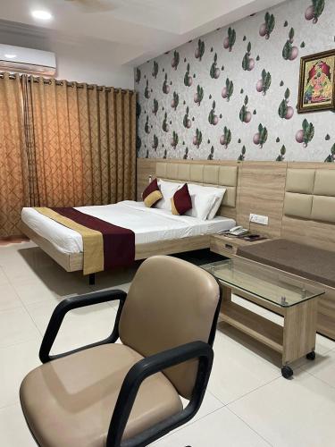a bedroom with a bed and a chair and a table at Hotel Seth Murlidhar Seva Sadan-Near Prem Mandir in Vrindāvan