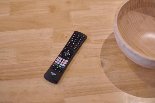 a remote control sitting on a table next to a bowl at Spacious Home for Large Families and Contractors in Wolverhampton