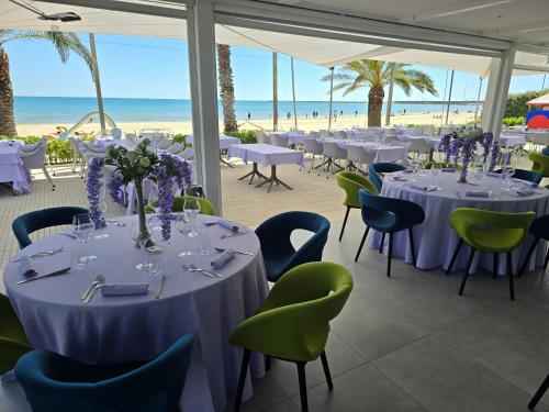 a banquet hall with tables and chairs and the beach at Valentino Resort in Grottammare