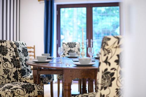 a wooden table with two chairs and a table with wine glasses at Spacious Home for Large Families and Contractors in Wolverhampton