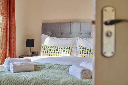 a bedroom with a large bed with towels on it at Spacious Home for Large Families and Contractors in Wolverhampton