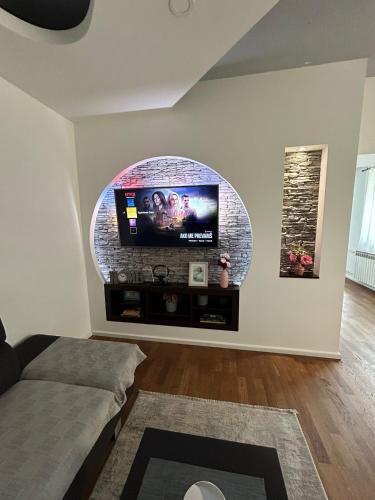 a living room with a flat screen tv on a wall at Apartman Gaby in Virovitica