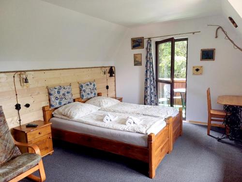a bedroom with a bed and a chair and a table at Willa na Bani - apartamenty i pokoje in Rabka