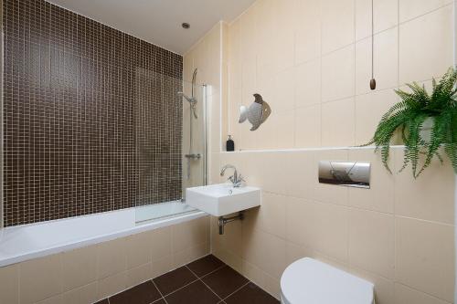 a bathroom with a white toilet and a sink at Spacious Home for Large Families and Contractors in Wolverhampton