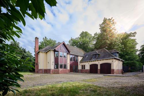 an old brick house with a garage in a yard at Spacious Home for Large Families and Contractors in Wolverhampton