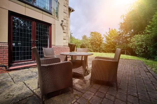 a table and chairs sitting on a brick patio at Spacious Home for Large Families and Contractors in Wolverhampton