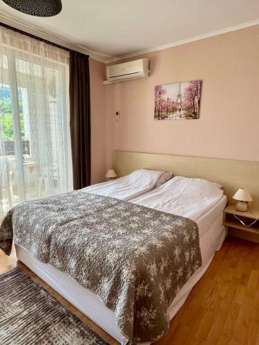 a bedroom with a large bed and a window at Mountain Breeze Villa in Rogachevo
