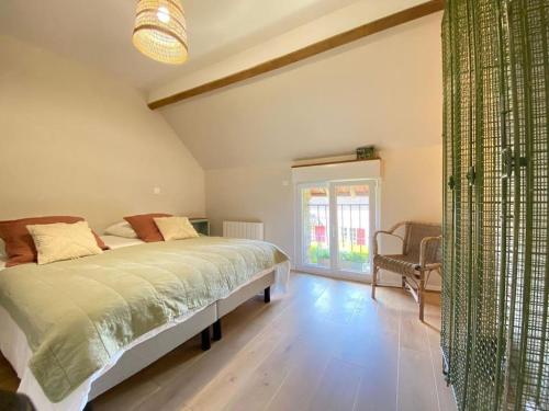 a bedroom with a bed and a large window at La mise en Seine in Venables