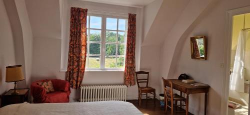 une chambre avec un lit, une fenêtre et un bureau dans l'établissement Domaine du Prieuré de Saint Martin à Lavardin, à Lavardin