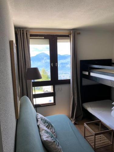 - une chambre avec des lits superposés, un canapé et une fenêtre dans l'établissement Studio cosy à Prapoutel, Les 7 Laux, Alpes, à Les Adrets