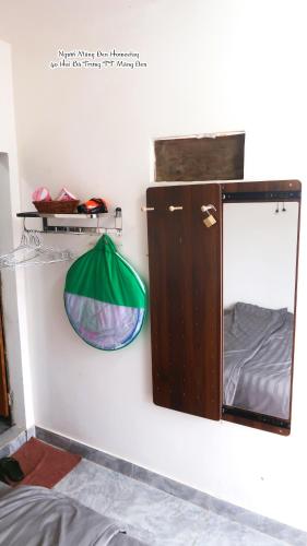 a mirror and a lamp on a wall with a bed at Người Măng Đen Homestay in Kon Von Kla