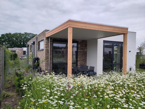 a house with a pavilion in a field of flowers at Weidezicht in Cromvoirt
