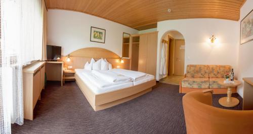 ein Hotelzimmer mit einem Bett und einem Stuhl in der Unterkunft Hotel Forer in Ladis