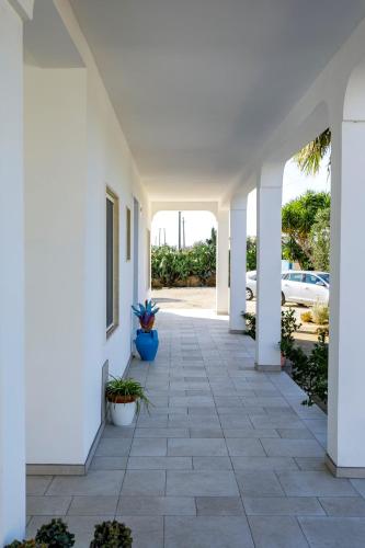 a hallway of a white house with potted plants at Villa Rebecca in Nardò