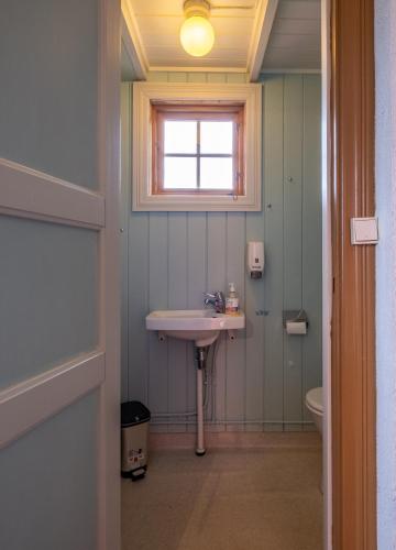 a bathroom with a sink and a window at Rorbuer på Lenvik Museum in Enga