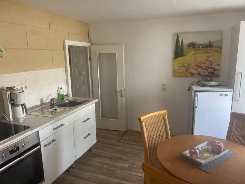 a kitchen with a table and a sink and a counter top at FeWo Großbadegast in Großbadegast