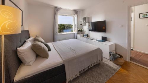a bedroom with a large bed and a window at Vista Porto Apartment in Mali Lošinj
