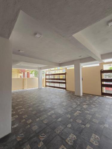 a large empty room with a tile floor in a building at Nandan Enclave in Mysore