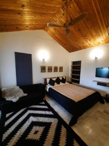 a bedroom with a bed and a ceiling at Bhurban Valley Cottages 3 in Bhurban