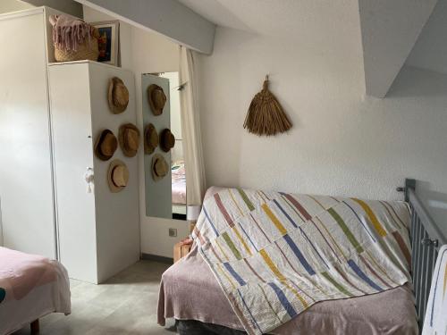 - une chambre avec un lit et un mur avec des chapeaux dans l'établissement Corse Calvi appt coté Mer, à Calvi
