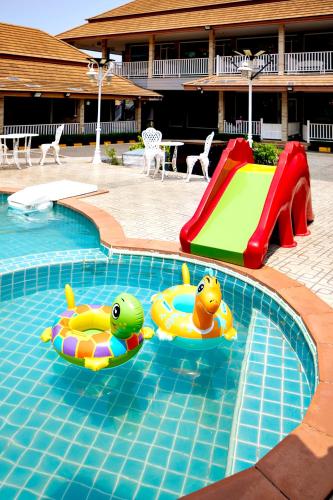 two rubbericans in a swimming pool with a slide at Baan Dara Resort in Sara Buri