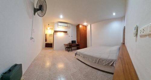 a bedroom with a bed and a desk in a room at Banchang home village in Ban Phayun