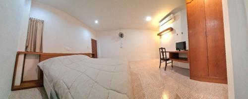 a bedroom with a bed and a desk in it at Banchang home village in Ban Phayun