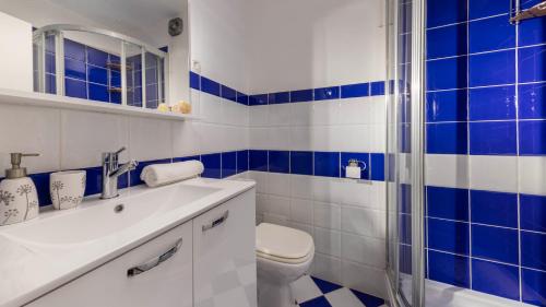 a blue and white bathroom with a toilet and a shower at Vista Porto Apartment in Mali Lošinj