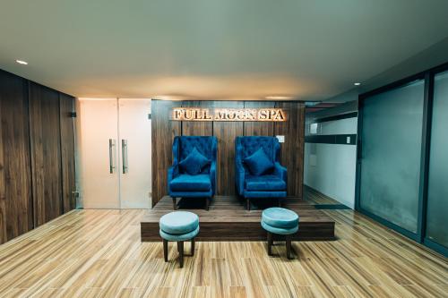 a waiting room with two blue chairs and a sign at Full Moon Apartments & Villa - Hoi An in Hoi An