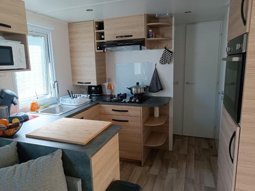 une cuisine avec des armoires en bois et un comptoir dans l'établissement Mobil-home tout confort camping Mar Estang à Canet en roussillon, à Canet