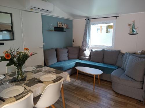un salon avec un canapé bleu et une table dans l'établissement Mobil-home tout confort camping Mar Estang à Canet en roussillon, à Canet