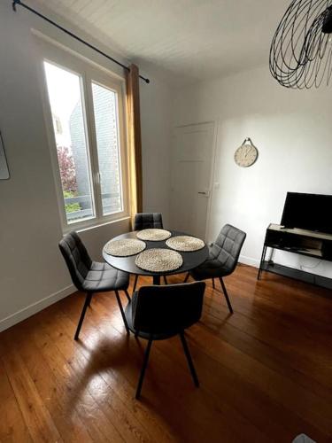 Cette chambre comprend une table, des chaises et un piano. dans l'établissement Saint Vincent Océane Le Havre, au Havre
