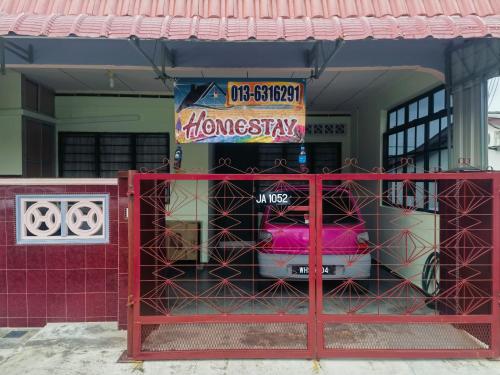 a red gate in front of a house at Urban Escape Homestay Melaka in Merlimau