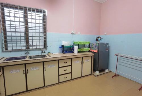 a kitchen with a sink and a refrigerator at Urban Escape Homestay Melaka in Merlimau