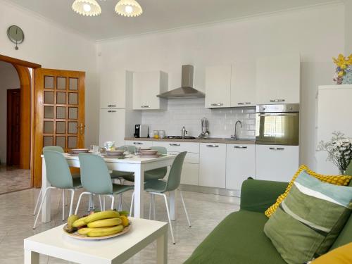a kitchen and dining room with a table with bananas on it at Villa Sole near the sandy beach, parking & wifi in Avola