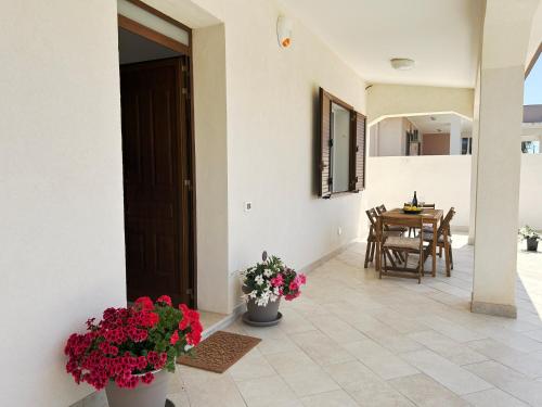 a house with two vases of flowers and a table at Villa Sole near the sandy beach, parking & wifi in Avola