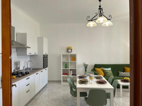 a kitchen and a living room with a table and chairs at Villa Sole near the sandy beach, parking & wifi in Avola