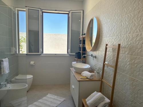 a bathroom with a sink toilet and a mirror at Villa Sole near the sandy beach, parking & wifi in Avola
