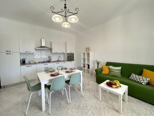 a living room with a green couch and a table at Villa Sole near the sandy beach, parking & wifi in Avola