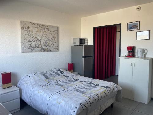 a bedroom with a bed and a refrigerator at Au rythme des Ferrys in Calais