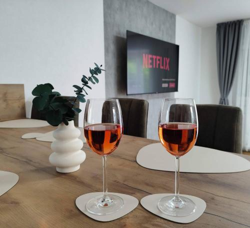 two glasses of wine sitting on a wooden table at Apartment Marissa in Billerbeck