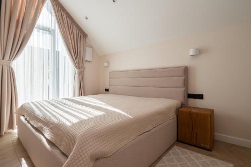 een slaapkamer met een bed en een groot raam bij LightSummerPalanga in Palanga