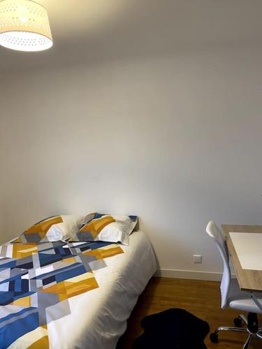 une chambre avec un lit, une table et un bureau dans l'établissement La baumiere 6 personnes, à Cholet