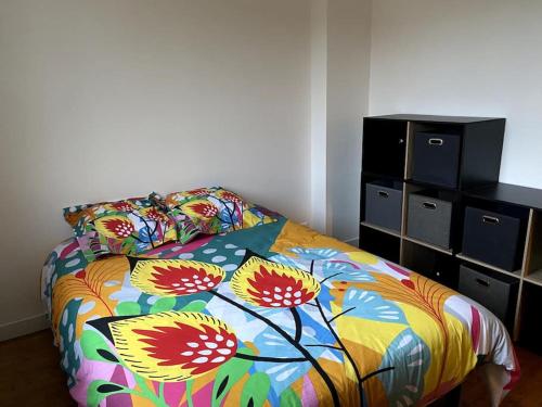 une chambre avec un lit avec une couette colorée dans l'établissement La baumiere 6 personnes, à Cholet